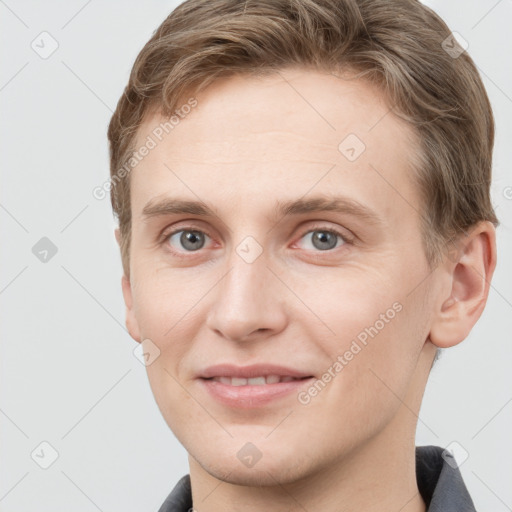 Joyful white young-adult male with short  brown hair and grey eyes