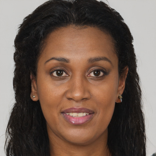 Joyful black young-adult female with long  brown hair and brown eyes
