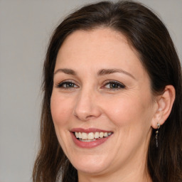 Joyful white adult female with long  brown hair and brown eyes