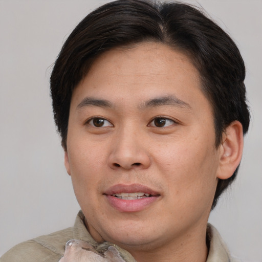 Joyful asian young-adult male with short  brown hair and brown eyes