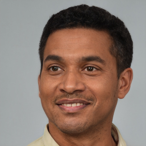 Joyful latino adult male with short  black hair and brown eyes