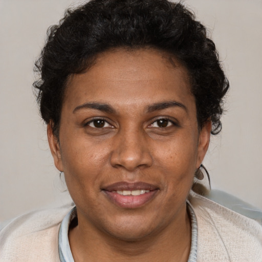Joyful black young-adult female with short  brown hair and brown eyes