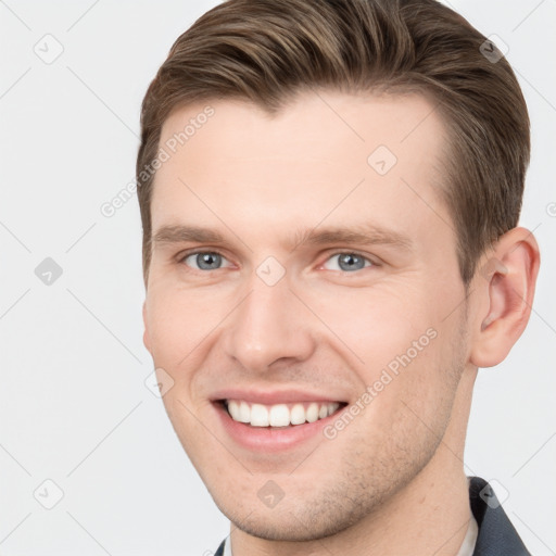 Joyful white young-adult male with short  brown hair and grey eyes