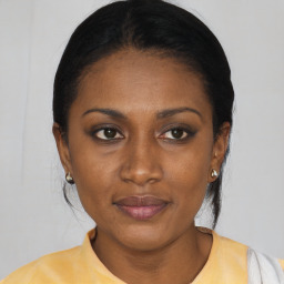 Joyful black young-adult female with short  black hair and brown eyes