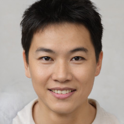 Joyful asian young-adult male with short  brown hair and brown eyes