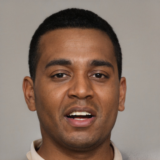 Joyful black young-adult male with short  black hair and brown eyes