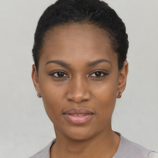 Joyful black young-adult female with short  black hair and brown eyes
