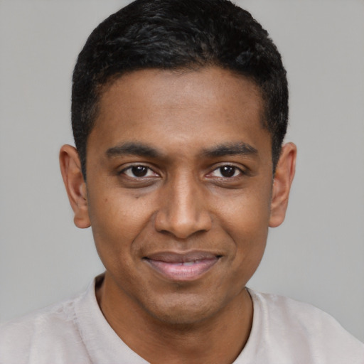 Joyful black young-adult male with short  black hair and brown eyes