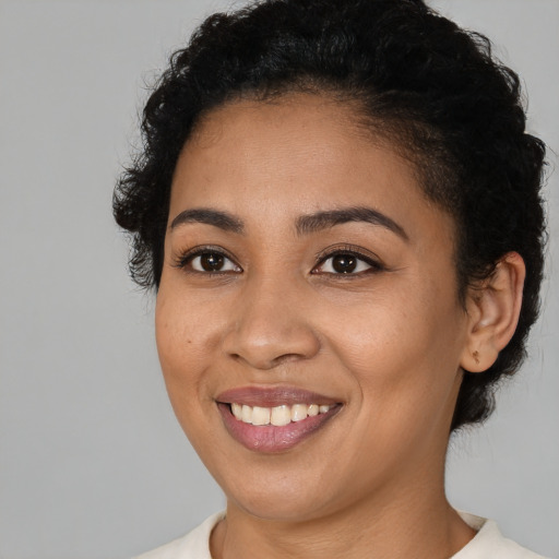 Joyful latino young-adult female with short  black hair and brown eyes