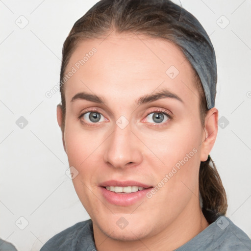 Joyful white young-adult female with short  brown hair and grey eyes