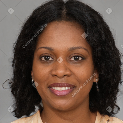 Joyful black young-adult female with long  brown hair and brown eyes