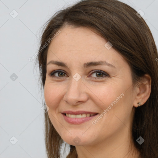 Joyful white adult female with long  brown hair and brown eyes