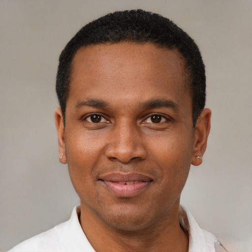 Joyful black young-adult male with short  black hair and brown eyes