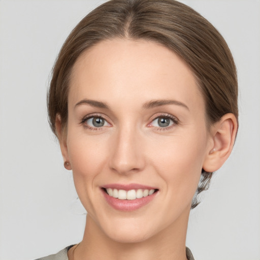 Joyful white young-adult female with medium  brown hair and grey eyes