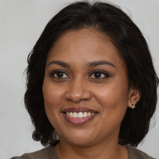 Joyful black young-adult female with medium  brown hair and brown eyes
