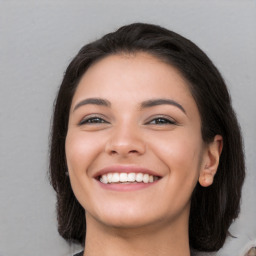 Joyful white young-adult female with long  black hair and brown eyes