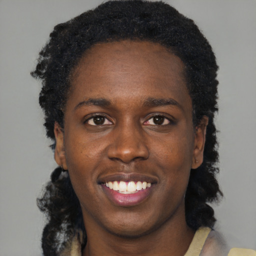 Joyful black young-adult female with short  black hair and brown eyes