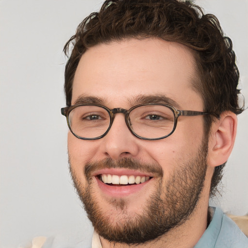 Joyful white young-adult male with short  brown hair and green eyes