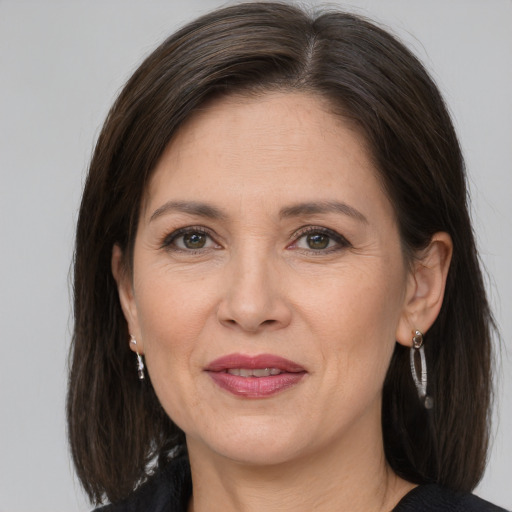 Joyful white adult female with medium  brown hair and grey eyes