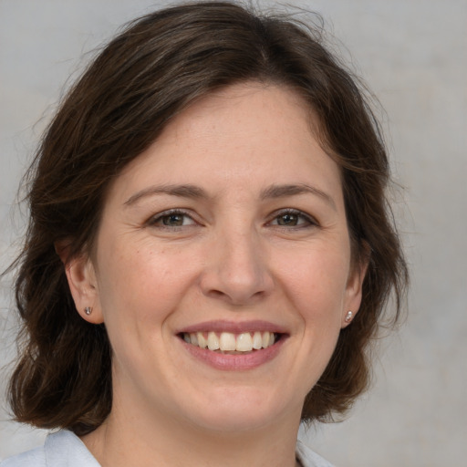 Joyful white adult female with medium  brown hair and brown eyes