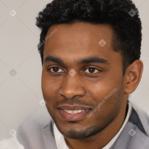 Joyful black young-adult male with short  black hair and brown eyes