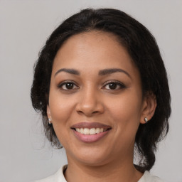 Joyful latino young-adult female with medium  brown hair and brown eyes