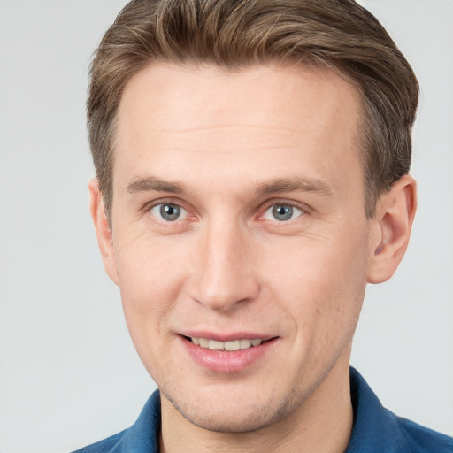 Joyful white young-adult male with short  brown hair and grey eyes