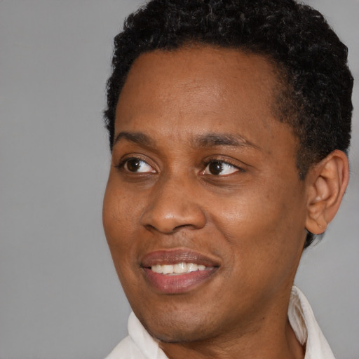 Joyful black young-adult male with short  brown hair and brown eyes