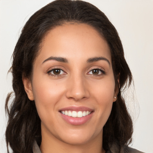 Joyful white young-adult female with long  brown hair and brown eyes