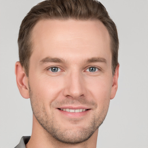 Joyful white young-adult male with short  brown hair and grey eyes