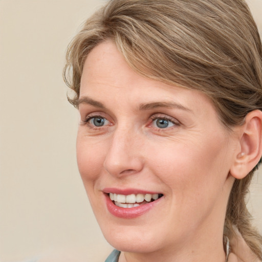 Joyful white adult female with medium  brown hair and blue eyes