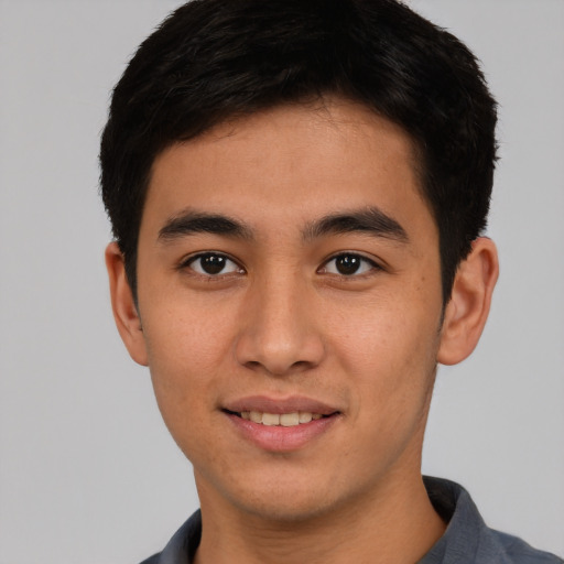 Joyful asian young-adult male with short  brown hair and brown eyes