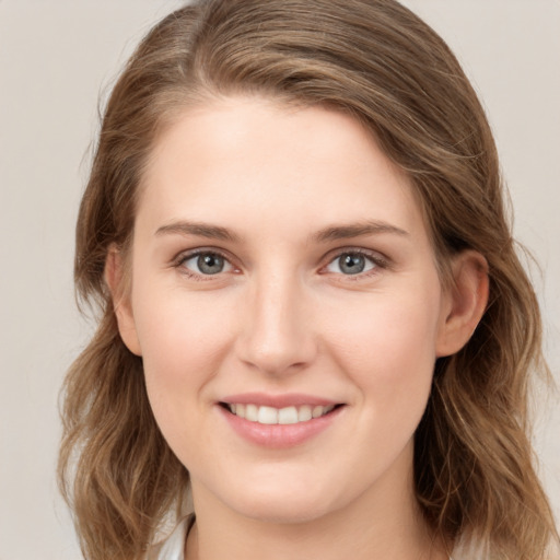 Joyful white young-adult female with long  brown hair and grey eyes