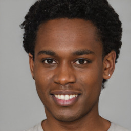 Joyful black young-adult male with short  brown hair and brown eyes