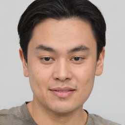 Joyful asian young-adult male with short  black hair and brown eyes