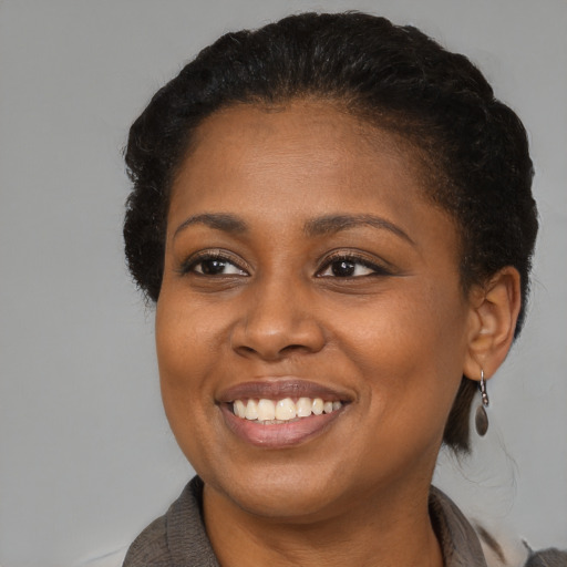 Joyful black young-adult female with medium  brown hair and brown eyes
