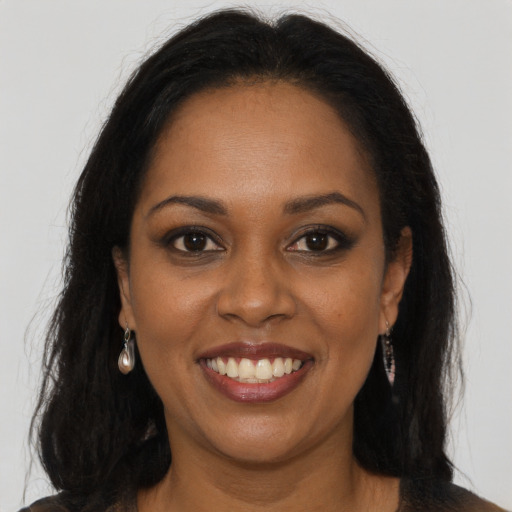 Joyful black young-adult female with long  brown hair and brown eyes