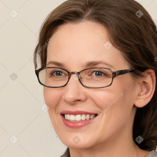 Joyful white adult female with medium  brown hair and grey eyes