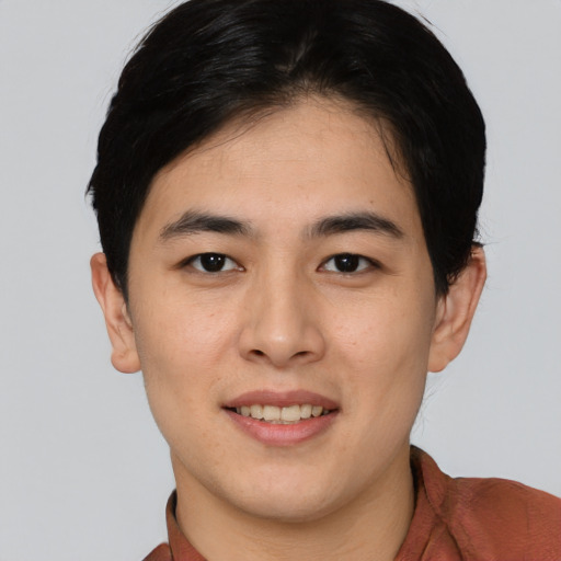 Joyful asian young-adult male with short  black hair and brown eyes