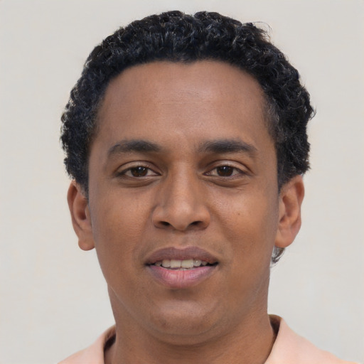 Joyful black young-adult male with short  black hair and brown eyes