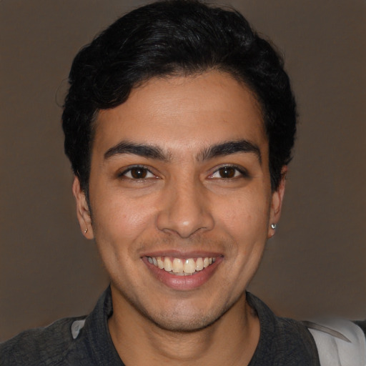 Joyful white young-adult male with short  black hair and brown eyes