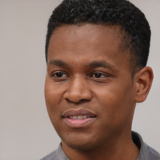 Joyful black young-adult male with short  black hair and brown eyes