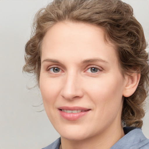 Joyful white young-adult female with medium  brown hair and blue eyes