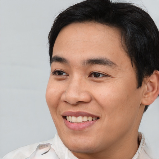 Joyful asian young-adult male with short  brown hair and brown eyes