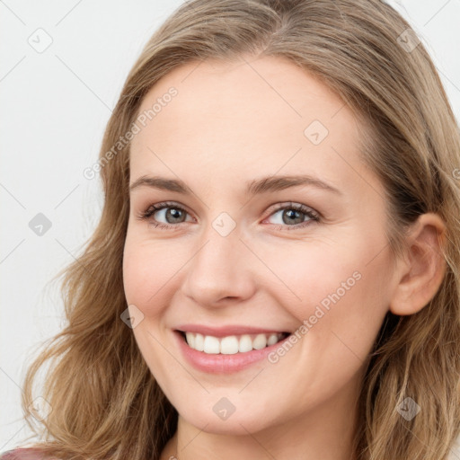 Joyful white young-adult female with long  brown hair and blue eyes