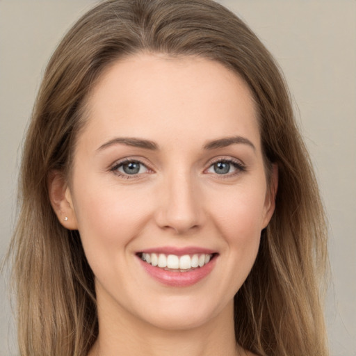 Joyful white young-adult female with long  brown hair and grey eyes