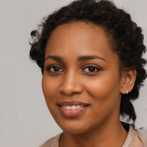 Joyful black young-adult female with medium  black hair and brown eyes