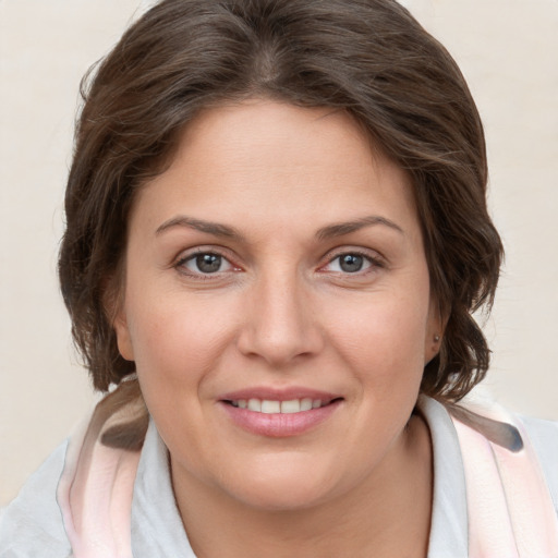 Joyful white young-adult female with medium  brown hair and grey eyes