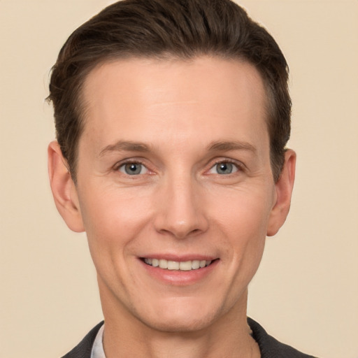 Joyful white adult male with short  brown hair and grey eyes