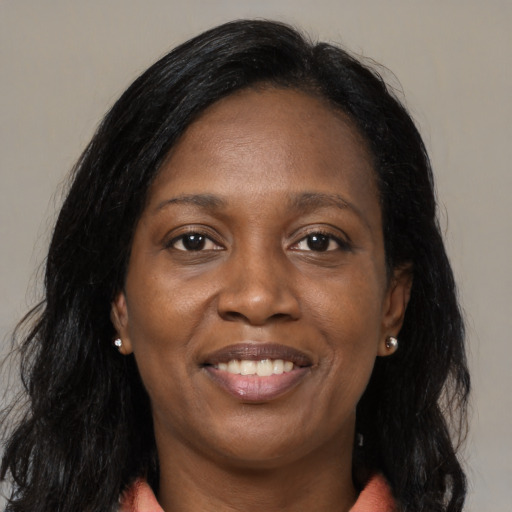 Joyful black adult female with long  brown hair and brown eyes